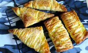 Chrupiące ciasto francuskie z serem żółtym, posypane sezamem, ułożone na kratce. Idealna przekąska.