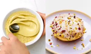 Pyszne pączki pistacjowe z lukrem i posypką z pistacji i płatków róży. Obok miska z kremem pistacjowym.