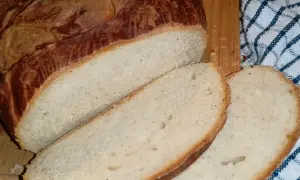 Puszysty chleb wielkanocny, pokrojony na kromki, z chrupiącą, złocistą skórką.