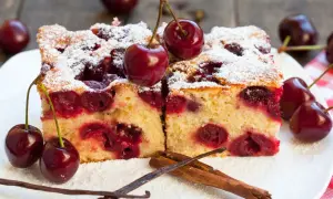Pyszne ciasto z czereśniami, posypane cukrem pudrem, z dodatkiem laski wanilii i cynamonu. Idealne na letnie popołudnie.