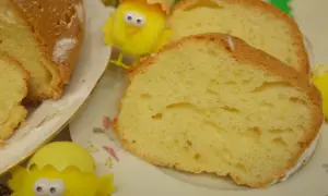Puszysta babka majonezowa, pokrojona na plastry, z ozdobnymi kurczaczkami wielkanocnymi.