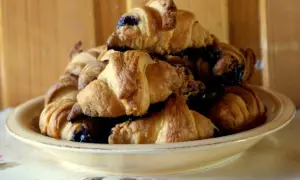 Stosik pysznych, świeżych croissantów z czekoladą, gotowych do zjedzenia.