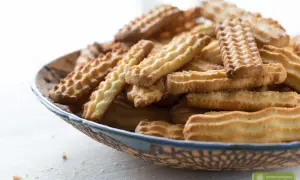 Stos ciasteczek na talerzu, idealnych do kawy. Prosty przepis na ciastka, który każdy może wypróbować.