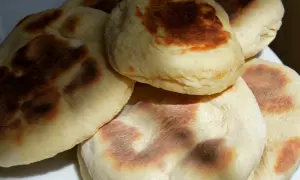 Stos chrupiących chlebków z patelni, lekko przypieczonych, gotowych do podania.