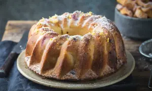 Złocista babka piaskowa, oprószona cukrem pudrem i skórką cytrynową, czeka na talerzu, by umilić popołudnie.
