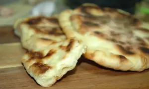Puszyste chlebki naan z Thermomixa, lekko przypieczone, gotowe do podania.