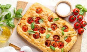 Pyszna focaccia z pomidorkami koktajlowymi i bazylią, idealna do pesto.