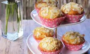 Słodkie muffinki z truskawkami i płatkami migdałów na dwupoziomowej paterze. Idealne na deser.