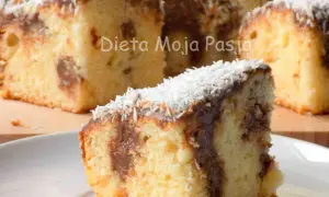 Pyszne ciasto krówka z polewą czekoladową i wiórkami kokosowymi, idealne na deser.