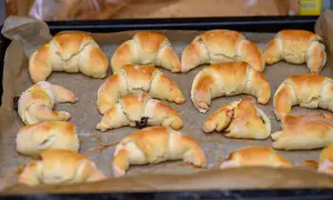 Szybkie rogaliki kruche, lekko zarumienione, ułożone na blasze wyłożonej papierem do pieczenia. Niektóre z nadzieniem.