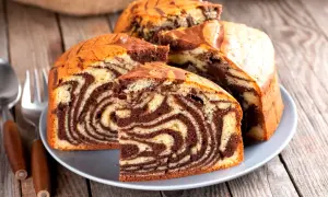 Pyszna babka marmurkowa z czekoladowymi i waniliowymi wzorami, pokrojona na talerzu, gotowa do degustacji.