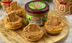 Urocze mini serniczki z kremem orzechowym i ciasteczkiem na wierzchu, obok słoiczek pasty z prażonych orzechów.