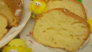 Puszysta babka majonezowa, pokrojona na plastry, z ozdobnymi kurczaczkami wielkanocnymi.