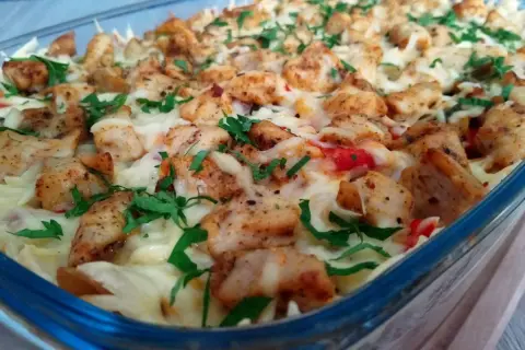 Pyszna zapiekanka gyros z kurczakiem, serem i ziołami w szklanym naczyniu.