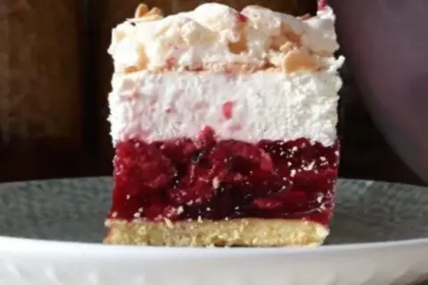 Pyszna malinowa chmurka bez pieczenia, z warstwą owoców, kremu i bezy, posypana płatkami migdałów.