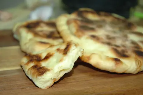 Puszyste chlebki naan z Thermomixa, lekko przypieczone, gotowe do podania.