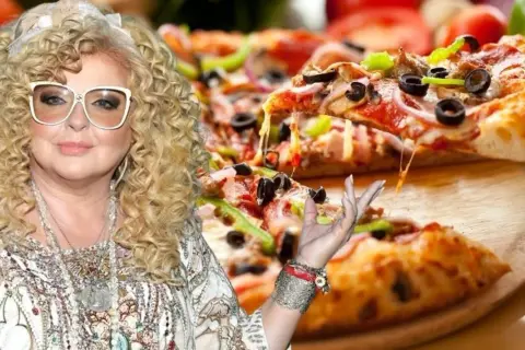 Magda Gessler zachęca do spróbowania swojej pysznej pizzy, która wygląda apetycznie z ciągnącym się serem.