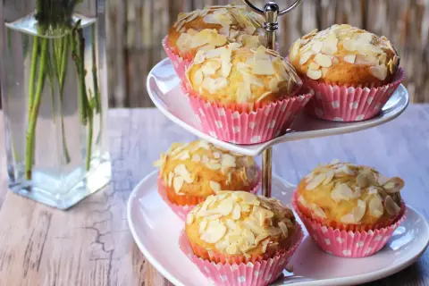 Słodkie muffinki z truskawkami i płatkami migdałów na dwupoziomowej paterze. Idealne na deser.