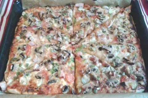Pyszna pizza na grubym cieście z pieczarkami, pomidorami i papryką, prosto z blachy. Idealna na rodzinny obiad.