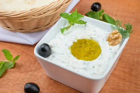 Pyszny sos tzatziki przepis na grecką ucztę. Kremowy jogurt, czosnek, ogórek, oliwa, oliwki i mięta. Idealny do pieczywa.