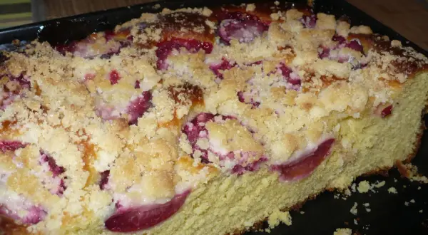 Pyszne drożdżówki ze śliwkami, posypane kruszonką, wyglądają apetycznie.