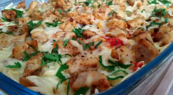 Pyszna zapiekanka gyros z kurczakiem, serem i ziołami w szklanym naczyniu.