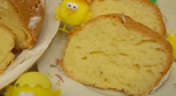 Puszysta babka majonezowa, pokrojona na plastry, z ozdobnymi kurczaczkami wielkanocnymi.