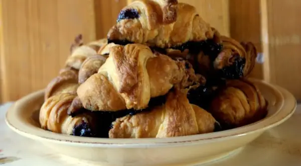 Stosik pysznych, świeżych croissantów z czekoladą, gotowych do zjedzenia.