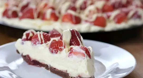 Pyszna tarta z mascarpone i truskawkami, polana białym lukrem. Idealna na deser.