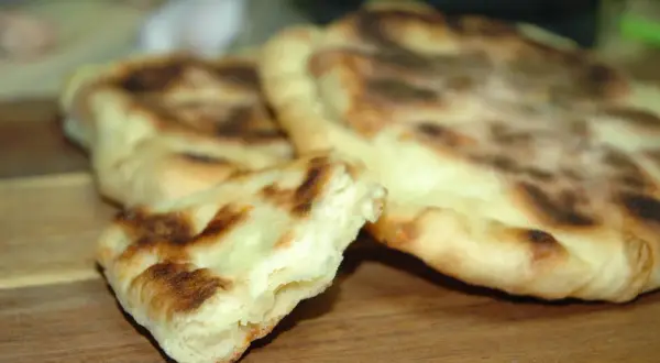 Puszyste chlebki naan z Thermomixa, lekko przypieczone, gotowe do podania.