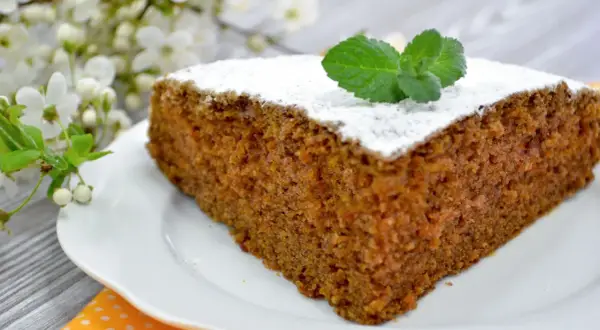 Wilgotne ciasto marchewkowe, posypane cukrem pudrem i udekorowane miętą. Kwestia smaku, która zachwyca wiosennym akcentem kwitnącej wiśni.