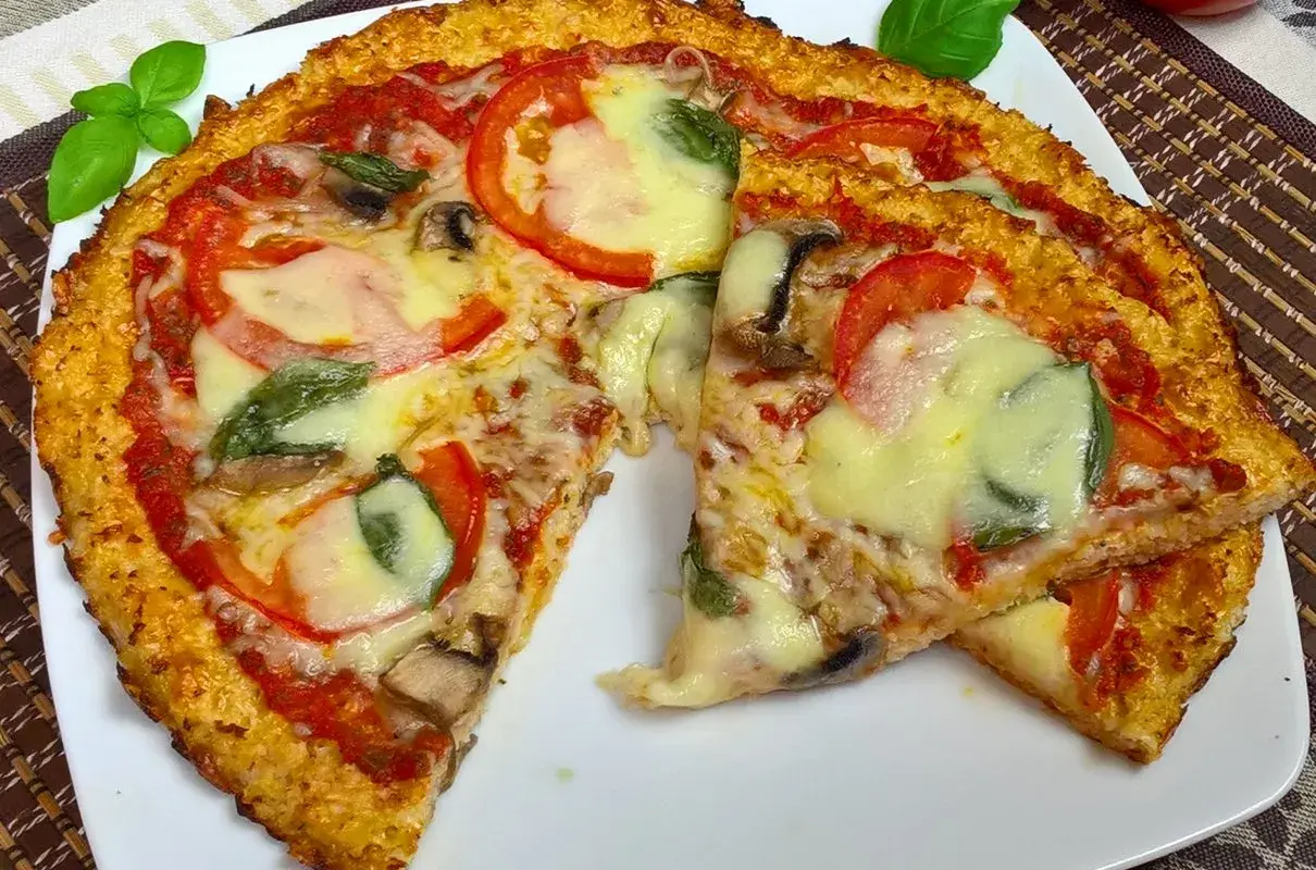 Pyszna pizza z kalafiora z pomidorami, mozzarellą i bazylią. Idealna na lekki obiad.