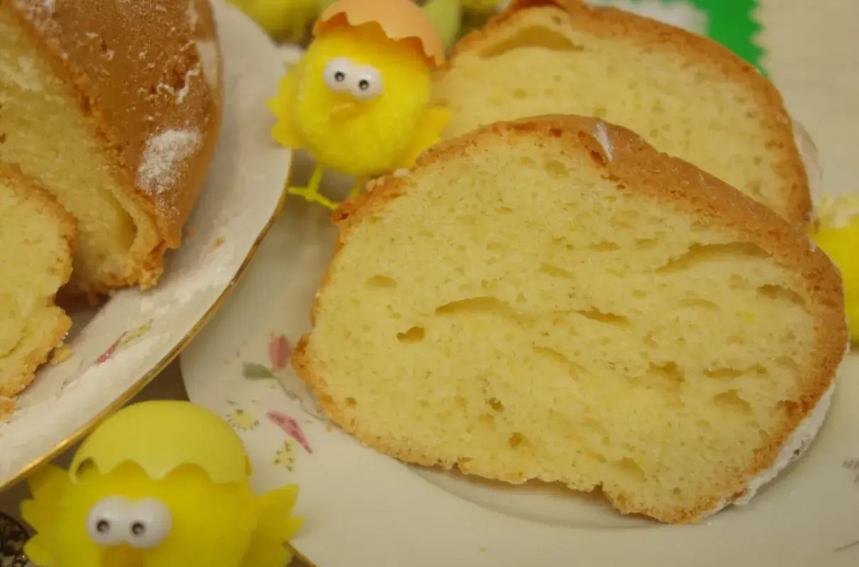 Puszysta babka majonezowa, pokrojona na plastry, z ozdobnymi kurczaczkami wielkanocnymi.