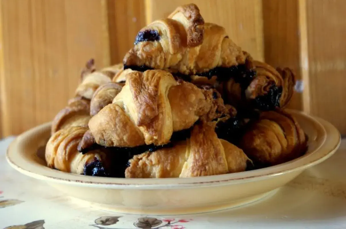Stosik pysznych, świeżych croissantów z czekoladą, gotowych do zjedzenia.
