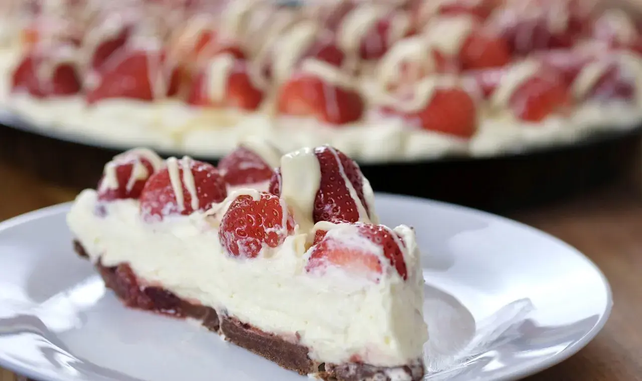 Pyszna tarta z mascarpone i truskawkami, polana białym lukrem. Idealna na deser.