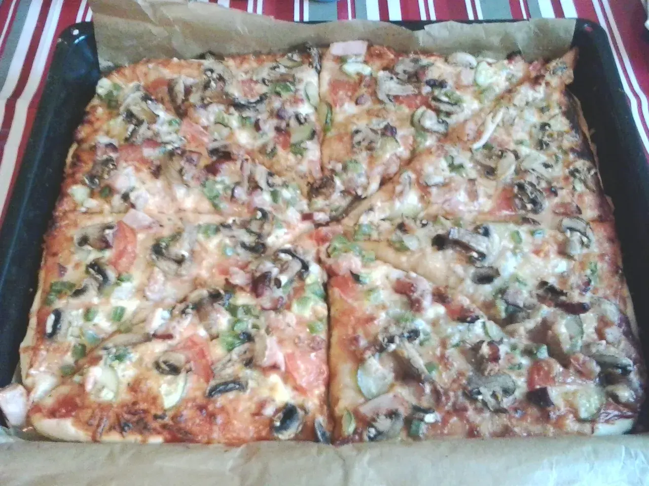 Pyszna pizza na grubym cieście z pieczarkami, pomidorami i papryką, prosto z blachy. Idealna na rodzinny obiad.