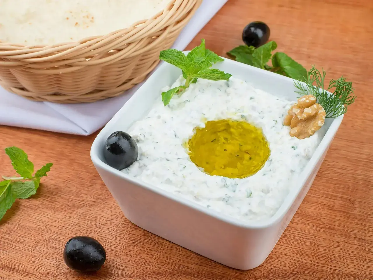 Pyszny sos tzatziki przepis na grecką ucztę. Kremowy jogurt, czosnek, ogórek, oliwa, oliwki i mięta. Idealny do pieczywa.