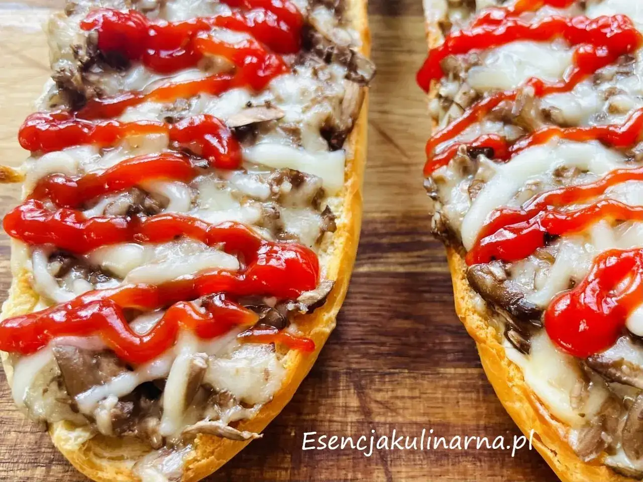 Pyszna zapiekanka z pieczarkami, roztopionym serem i ketchupem, podana na chrupiącej bagietce. Idealna na szybki obiad.
