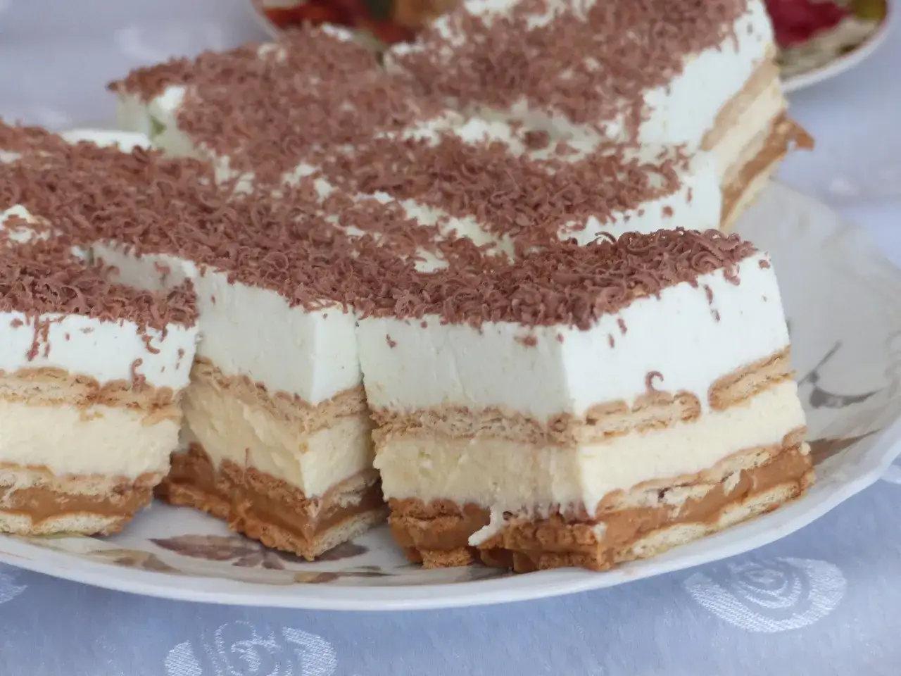 Pyszne ciasto pychotka bez pieczenia, warstwowe, z kremem i karmelem, posypane czekoladą.