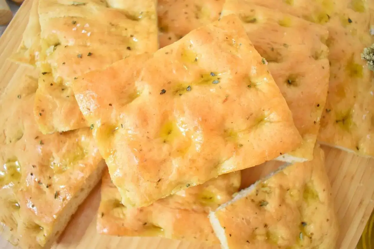 Pyszna focaccia z ziołami i oliwą, idealna do każdego posiłku. Prosty przepis na domową focaccię.