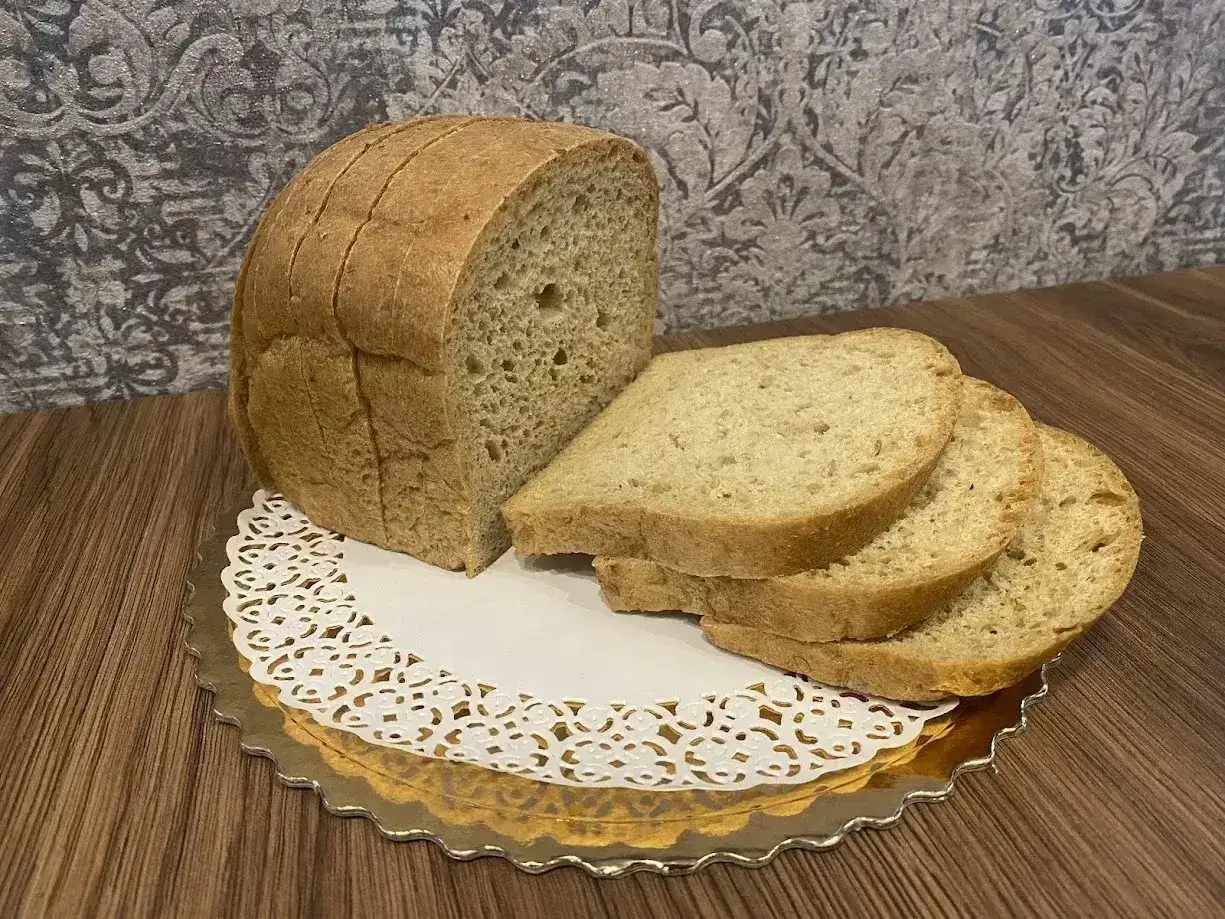 Chleb keto z mąki kokosowej, pokrojony w kromki, prezentuje się apetycznie na złotym talerzyku.