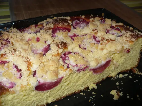 Pyszne drożdżówki ze śliwkami, posypane kruszonką, wyglądają apetycznie.