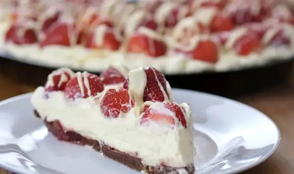 Pyszna tarta z mascarpone i truskawkami, polana białym lukrem. Idealna na deser.