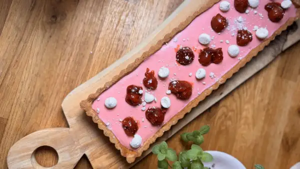 Pyszne ciasto kruche bezglutenowe z różowym kremem, wisienkami i bezą. Idealne na deser.